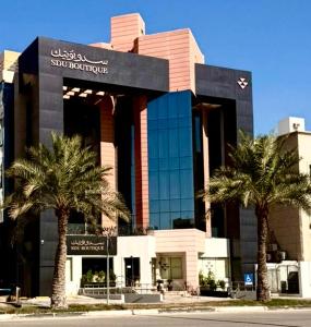 a building with palm trees in front of it at سدو بوتيك الخبر in Al Khobar