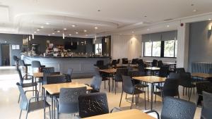 a restaurant with tables and chairs and a bar at Apartamentos Baños de Ledesma in Salamanca