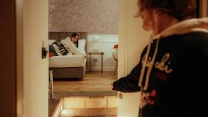 a woman sitting on a bed looking in a mirror at Palazzo Franceschini in Cascia