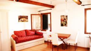 een woonkamer met een rode stoel en een tafel bij Venice Resorts in Venetië