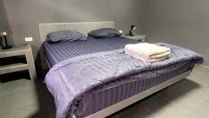 a bed with purple sheets and pillows in a bedroom at Dan Mai Homestay in Trat +4 photos