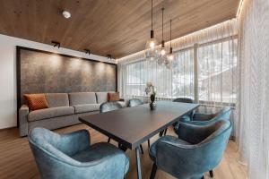 a dining room with a table and blue chairs at Chalet Fliana Deluxe in Ischgl