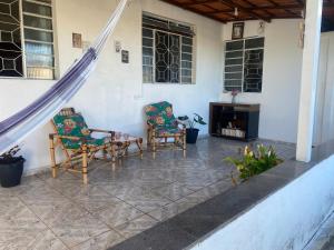 a patio with two chairs and a fireplace at Pousada da Vânia in Vespasiano
