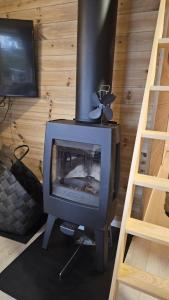 a fireplace in a room with a tv and a ladder at Hyttekos i Telemark in Åmli