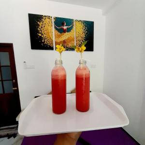 two vases on a table with flowers in them at Ashan Villa Ahungalla in Ahungalla