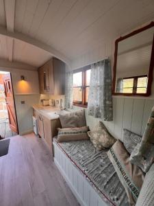 a living room with a couch in a tiny house at Orchard Shepherds Hut in Calstock