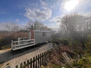 a tiny house on the side of a fence at Orchard Shepherds Hut in Calstock