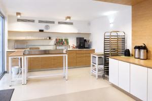 a large kitchen with white cabinets and a counter at Silvio-Gesell-Tagungsstätte in Wuppertal