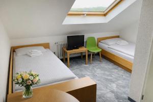 a small room with two beds and a tv at Silvio-Gesell-Tagungsstätte in Wuppertal
