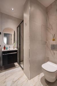 a bathroom with a shower and a toilet and a sink at Blueloft 65 I Apartment with Balcony and City View in Tashkent +8 photos