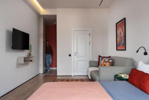 a living room with a couch and a tv on a wall at Blueloft 65 I Apartment with Balcony and City View in Tashkent