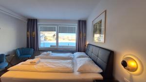 a hotel room with a bed and a window at Panorama Apartments - Steinbock Lodges in Zell am See