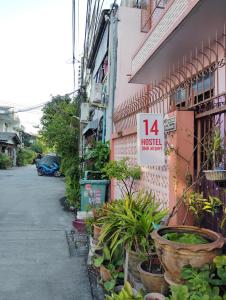 a sign on the side of a building with plants at 14 Hostel DMK airport in Bang Khen