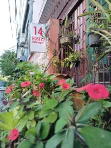 a building with red flowers and a sign on it at 14 Hostel DMK airport in Bang Khen +50 photos