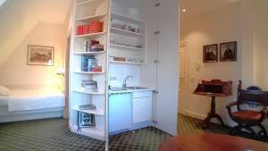 a kitchen with a sink and a room with a bed at Herrenhaus Appartement 16 in Lüdersburg