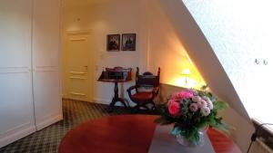 a room with a table with a vase of flowers at Herrenhaus Appartement 16 in Lüdersburg
