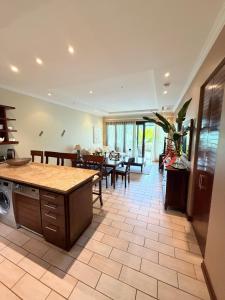 a kitchen and living room with a table and chairs at Exotic Trove in Eden Island