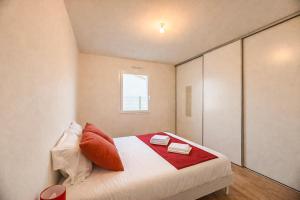 a bedroom with a large bed with red pillows at Maison 5-6 personnes -15 min du Parc - Parking -by R&G in La Pommeraie-sur-Sèvre