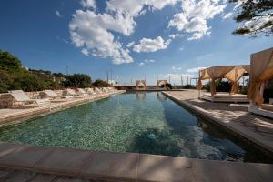 a pool with chaise lounge chairs and a swimming pool at Approdo Boutique Hotel Leuca in Leuca