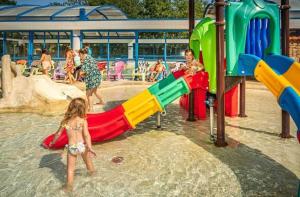 a little girl standing in the water at a playground at ZEcamping familial espace aquatique pet friendly in Argelès-sur-Mer +22 photos