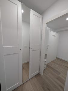 an empty closet with white cabinets and a mirror at Bajo Alcobendas in Alcobendas