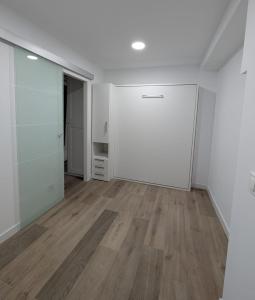 an empty room with a white door and wooden floors at Bajo Alcobendas in Alcobendas