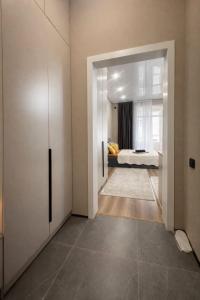 a bedroom with a door leading to a bedroom with a bed at Современный апартамент Tandau в центре in Almaty