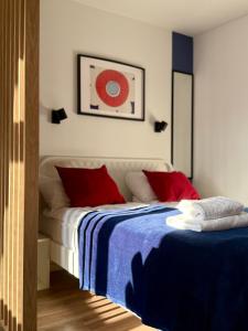 a bedroom with a bed with blue and red pillows at Przy Ratuszu Idealny dla par Dzikie wino by Rentoom in Toruń