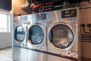 three washing machines are stacked in a room at コート エトワレ マエザト-新築アパートメントホテル- in Ishigaki Island