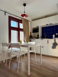 a white kitchen with a white table and chairs at Przy Ratuszu Idealny dla par Dzikie wino by Rentoom in Toruń +18 photos