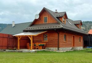 a large wooden cabin with a gambrel roof at Chata vo dvore in Osturňa