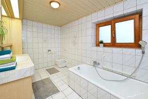 a white bathroom with a tub and a toilet at Ferienhof Kopf in Mäder