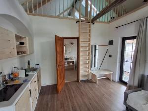 a kitchen with a spiral staircase in a room at Merino vendégház in Tiszabecs