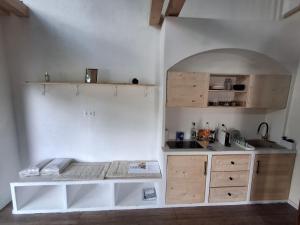 a white kitchen with a counter and a sink at Merino vendégház in Tiszabecs +13 photos