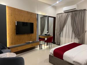 a hotel room with a bed and a flat screen tv at Holiday One Hotel & Suites - DHA-8 in Karachi