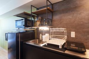 a kitchen with a sink and a refrigerator at コート エトワレ マエザト-新築アパートメントホテル- in Ishigaki Island