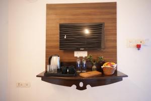 a shelf with a television on a wall at Beachouse Beachfront Cottages And Suites in Calangute