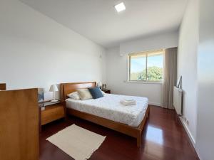 a bedroom with a bed and a window at Secret Spot Apartment - Quinta da Barca in Esposende +24 photos