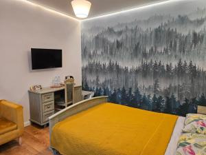 a bedroom with a yellow bed and a desk and a wall at POD ORŁEM in Wałcz