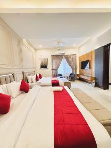 a large hotel room with two beds with a red rug at Holiday One Hotel & Suites - DHA-8 in Karachi +60 photos