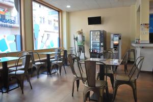 a restaurant with tables and chairs and a mannequin in the window at Senda Sur in Porriño