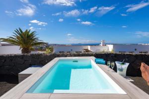 a swimming pool with a view of a villa at Dream Bocayna Village in Playa Blanca