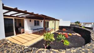 a house with a patio with a table and a couch at Dream Bocayna Village in Playa Blanca
