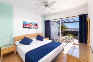 a bedroom with a bed and a balcony with a patio at Dream Bocayna Village in Playa Blanca +20 photos