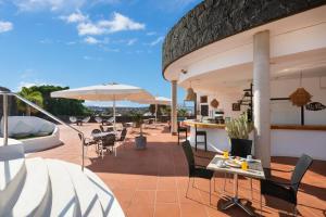 a patio with chairs and tables and umbrellas at Dream Bocayna Village in Playa Blanca