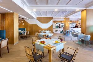 a dining room with tables and chairs and a restaurant at Gran Tacande Wellness & Relax Costa Adeje in Adeje