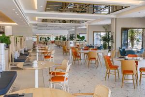 an empty restaurant with tables and chairs and tablesktop at Hotel Cristina by Tigotan Las Palmas - Adults Only in Las Palmas de Gran Canaria