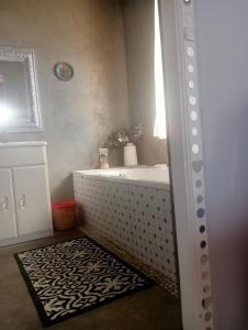 a bathroom with a bath tub and a rug at Nirvana in Struisbaai