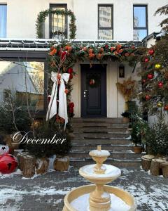 a house decorated for christmas with a fountain in front of it at Mosh Mosh Boutique Hotel in Almaty