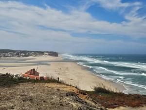 a view of a beach with a house and the ocean at Óbidos Lagoon Refuge in Foz do Arelho +91 photos
